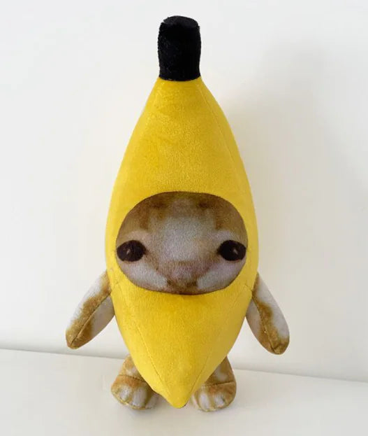 Stuffed toy shaped like a banana with a face on a white background