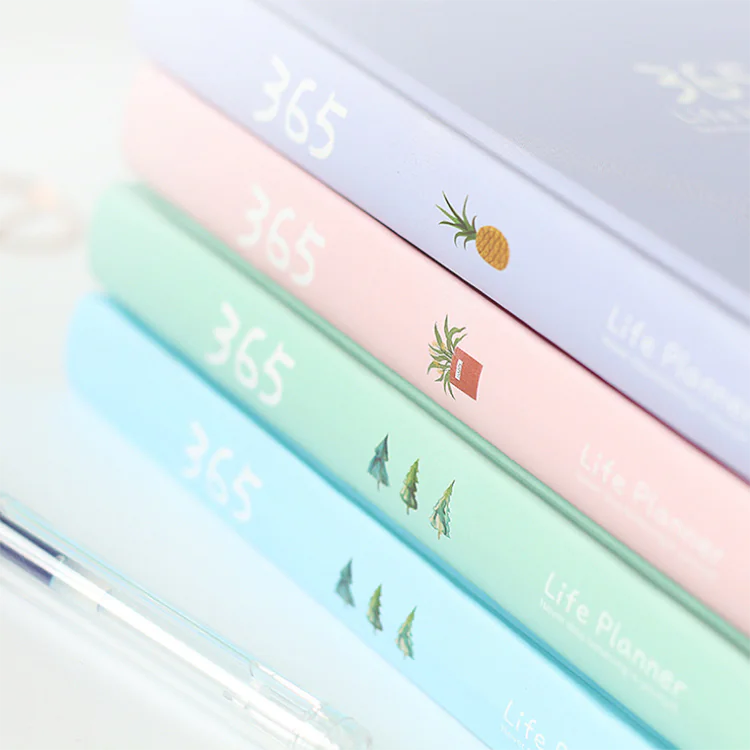 Set of colorful planners with pineapple and plant designs on a white background