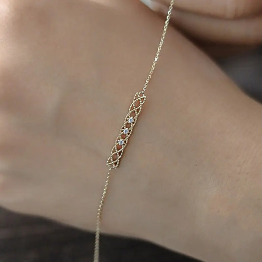 Delicate gold necklace with a small diamond on a person's neck
