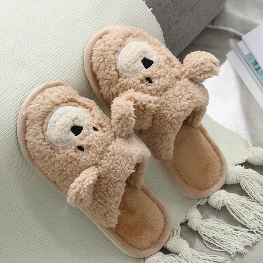 Pair of teddy bear-shaped slippers with tassels on a light surface.