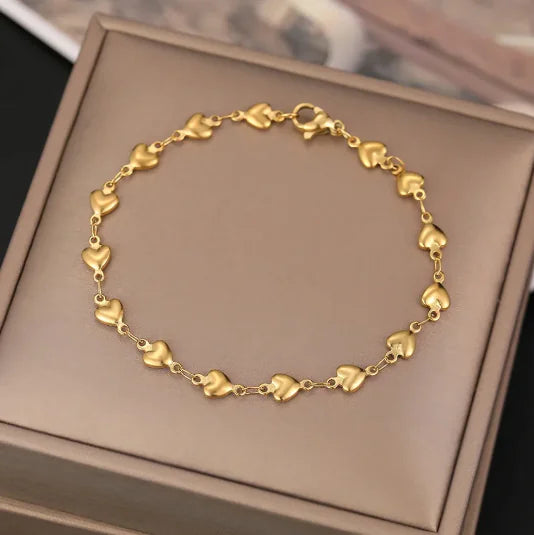 Gold heart-shaped bracelet on a brown box