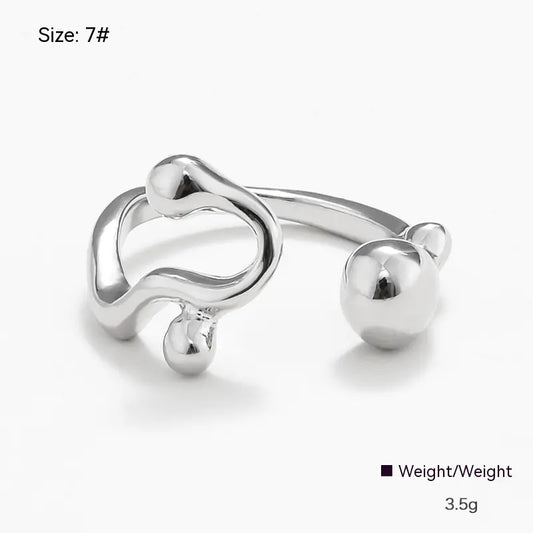 Silver open ring with a heart and ball design on a white background
