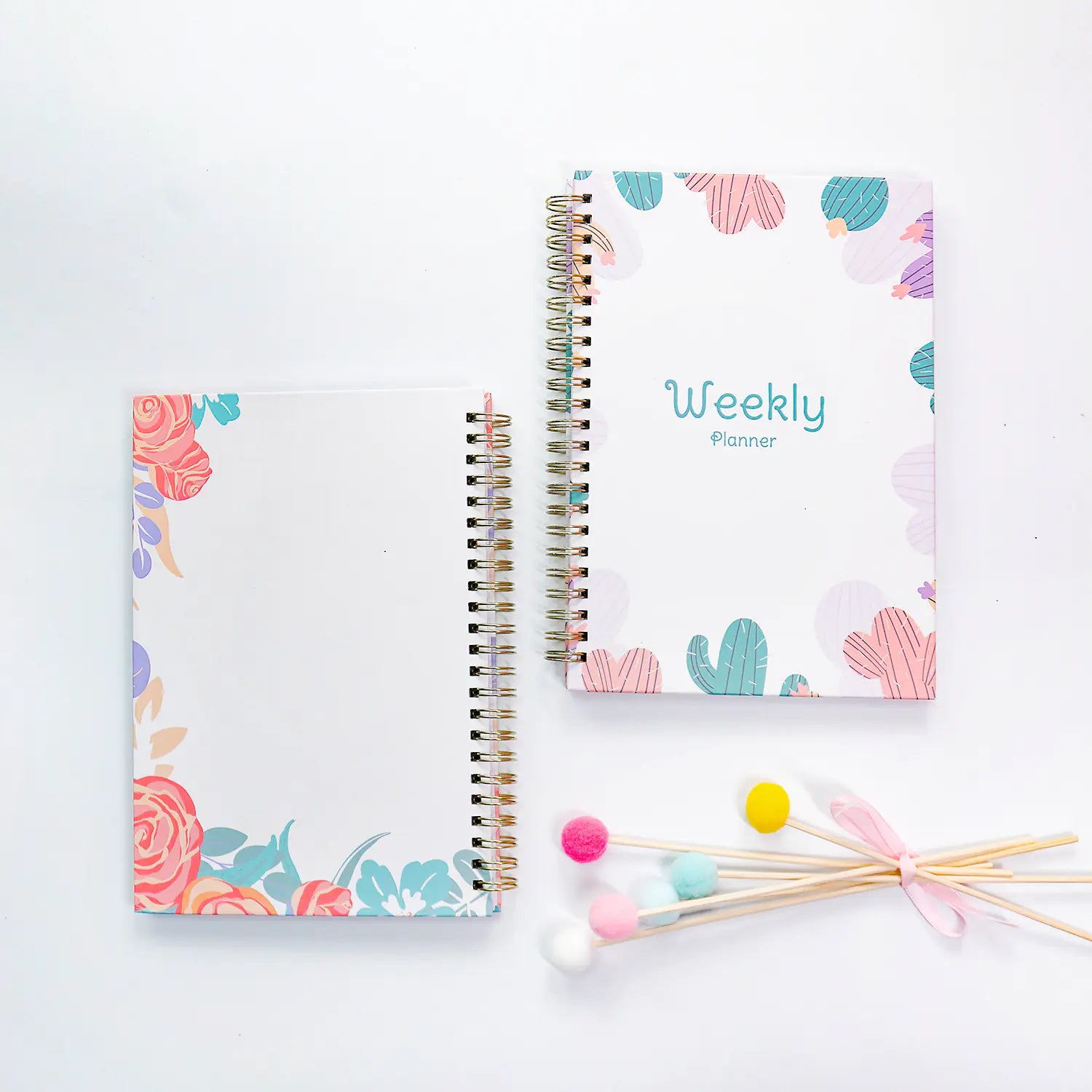 Two spiral-bound planners with floral and cactus designs on a white background.