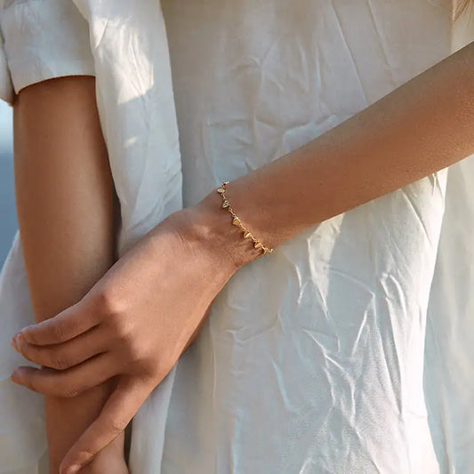 18K gold-plated heart-link chain bracelet displayed on women's wrist.