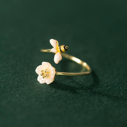 Gold rings with floral designs on a green textured background