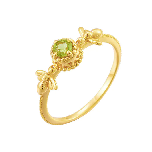 Gold ring with a green gemstone on a white background