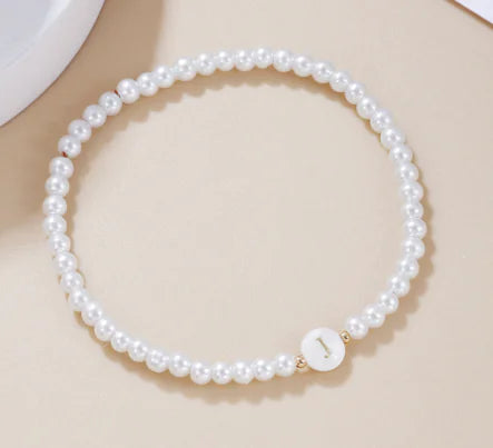 Pearl necklace with a gold clasp on a beige background