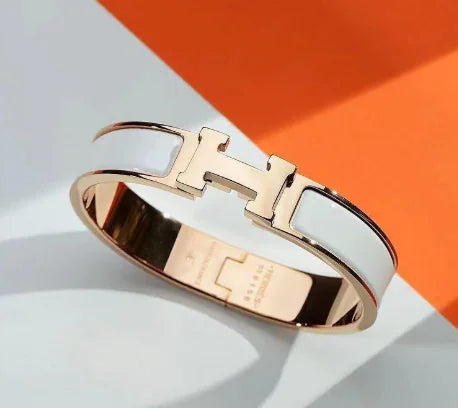 Rose gold bracelet with a prominent 'H' logo on a light background